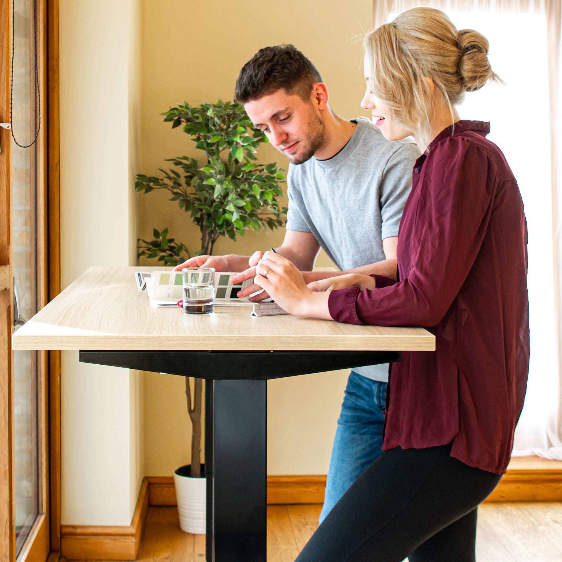 Man and woman standing at bluetooth standing desk.