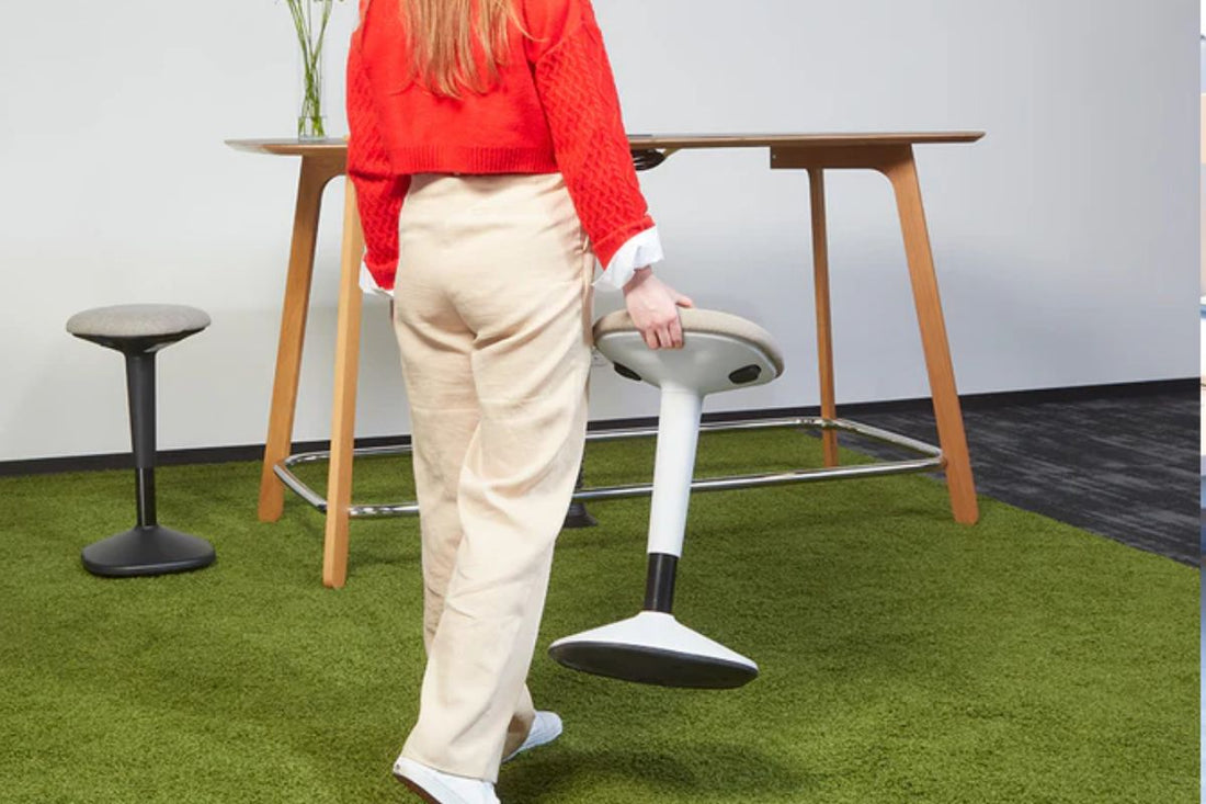 Woman holding sit-stand stool.