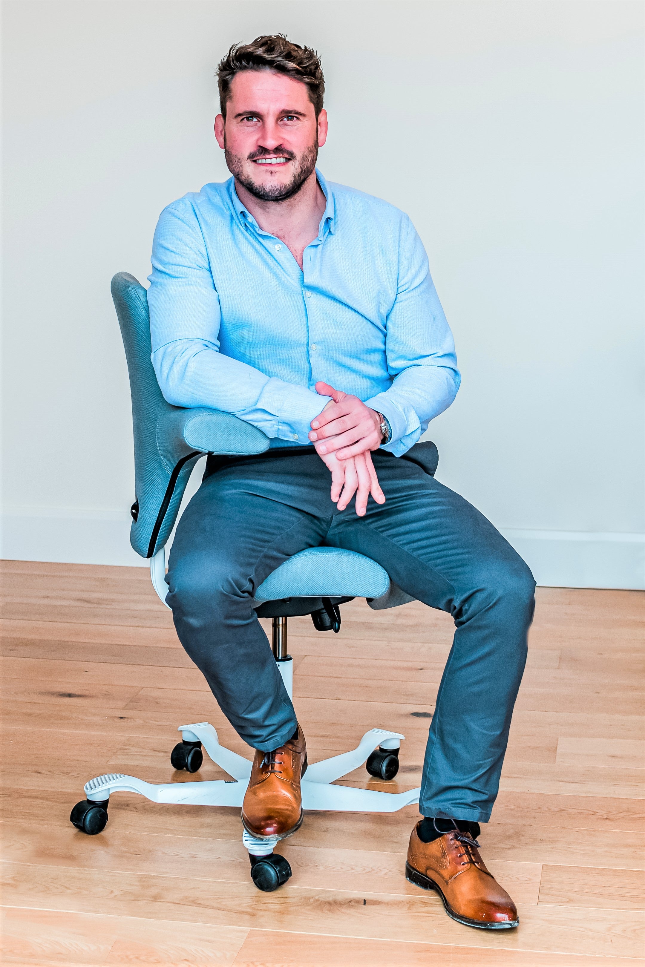 Front view of man sat on a ergonomic chair.