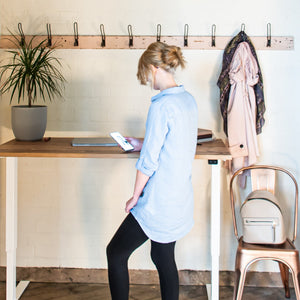 Woman stood at Malmö Dual Motor Height Adjustable Standing Desk.