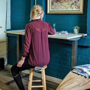 Woman sat at the Stockholm signature adjustable electric desk.