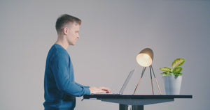 Man at standing desk using Gymba balance board