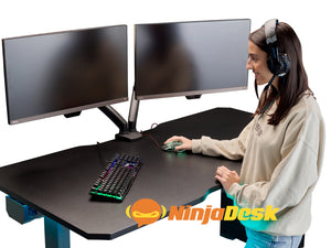Woman using NINJA Professional Extreme Height Adjustable Gaming Desk.